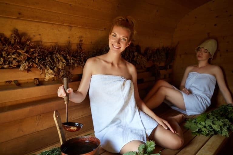 Frau in Handtuch macht Sauna-Aufguss - Titelbild Sauna-Thermometer und Hygrometer