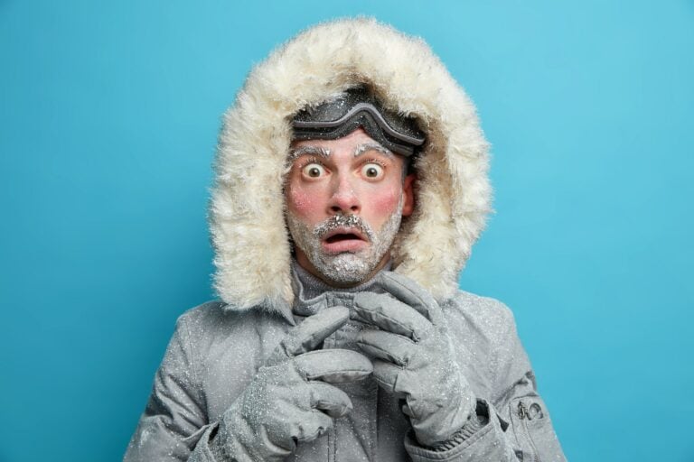 frierender Mann in dicker Winterjacke guckt erstaunt - Titelbild zu Kryosauna und Kältetherapie